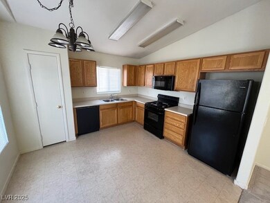 Kitchen featuring black appliances, light countert