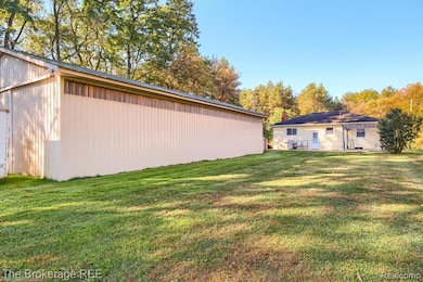 View of green lawn featuring an outbuilding