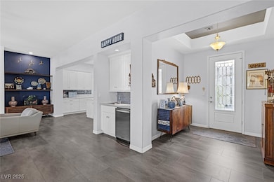 Entrance foyer featuring a raised ceiling, baseboa