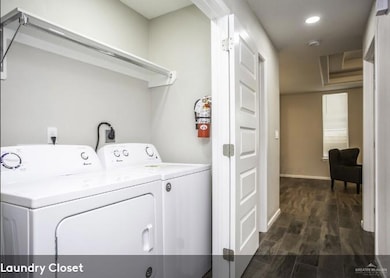 Washroom with laundry area, dark wood-style flooring, independent washer and dryer, baseboards, and recessed lighting