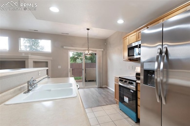 Kitchen featuring appliances with stainless steel finishes, light countertops, light tile patterned flooring, pendant lighting, and recessed lighting