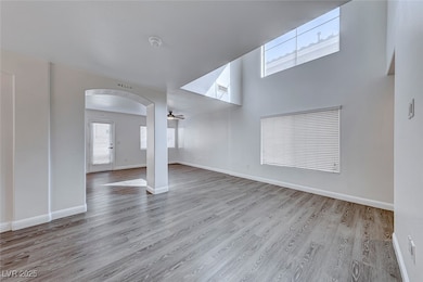 Unfurnished living room with arched walkways, wood