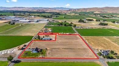 Aerial view of sparsely populated area with property parcel outlined and mountains