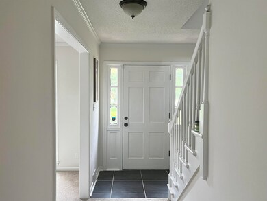 Entrance foyer with dark tile patterned floors and