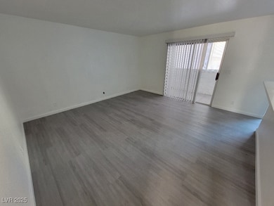 Empty room featuring dark wood finished floors and baseboards