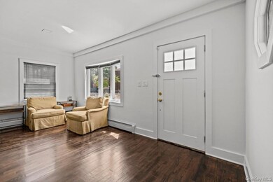 Entryway featuring dark wood-style floors and a baseboard radiator