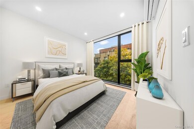 Bedroom with a wall of windows, light wood-style floors, and recessed lighting