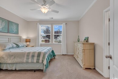 Bedroom with ceiling fan, ornamental molding, and 