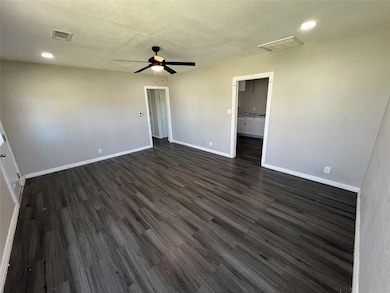 Empty room with dark wood-type flooring, a ceiling
