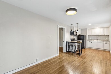 Kitchen with black appliances, white cabinetry, ba