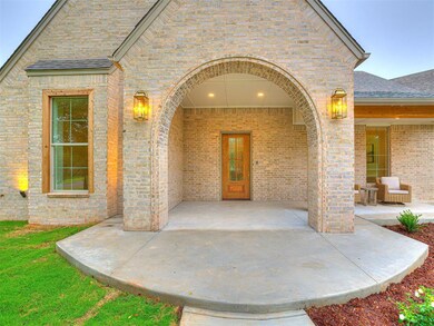 Doorway to property featuring brick siding, a shingled roof, and a patio area