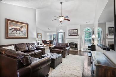 Family area featuring, cathedral ceilings, new windows, a fireplace, ceiling fan, wood floors and natural light