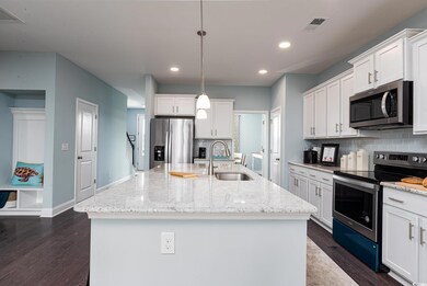 Kitchen with stainless steel appliances, a sink, tasteful backsplash, recessed lighting, and white cabinetry