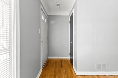Hallway featuring hardwood / wood-style flooring and a textured ceiling