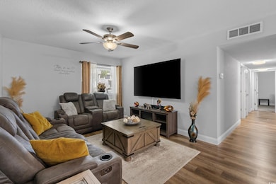 Living area featuring baseboards, visible vents, l