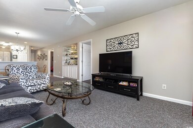 Carpeted living room with ceiling fan with notable