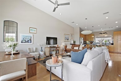 Living area with light wood-style flooring, ceiling fan, and recessed lighting