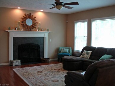 Great room has a wood burning fireplace with a gas