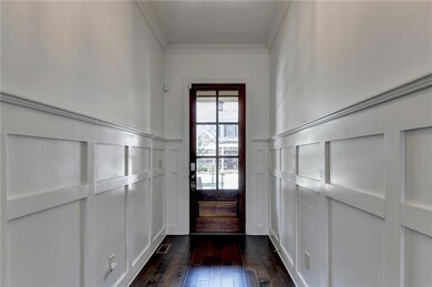 Doorway with a decorative wall, crown molding, dar