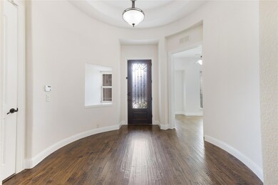 Foyer with visible vents, baseboards, and dark woo