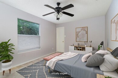 staged Carpeted bedroom featuring ceiling fan and 