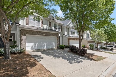Multi unit property with a garage, brick siding, and concrete driveway