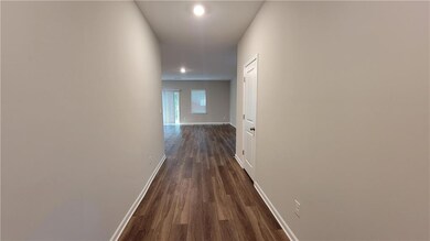 Hallway with dark wood-style floors and recessed lighting
