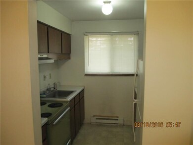 Galley kitchen equipped with stove, refrigerator, 