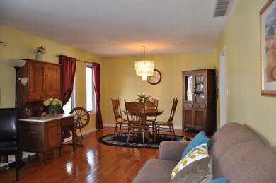Lovely dining room with hardwood floors opens to e