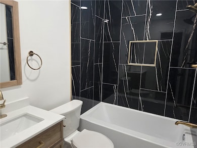 Bathroom with toilet, vanity, and bathtub / shower