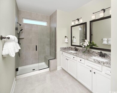 Full bathroom featuring a shower stall, double vanity, and tile patterned flooring
