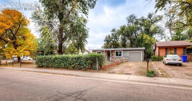 View of front of house with driveway, a fenced front yard, a garage, and stone siding