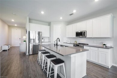 Kitchen with backsplash, sink, an island with sink