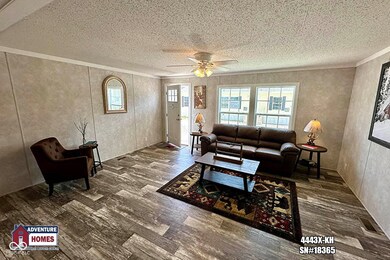 living area with wood finished floors, a textured ceiling, ornamental molding, and a ceiling fan