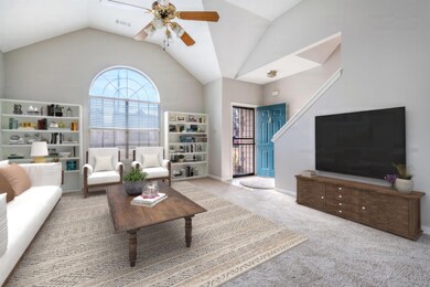 Carpeted living room with ceiling fan and lofted c
