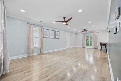 Unfurnished living room featuring crown molding, ceiling fan, recessed lighting, and light wood-style floors