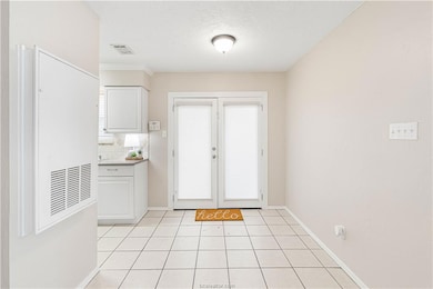 Entryway featuring tile patterned flooring, french doors, and a textured ceiling