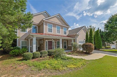 Craftsman house with covered porch, a standing seam roof, a front lawn, a garage, and stone siding