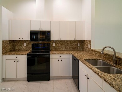 Kitchen with dark stone countertops, sink, black a