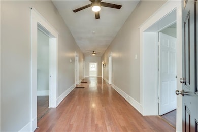 Hallway with light wood finished floors and baseboards