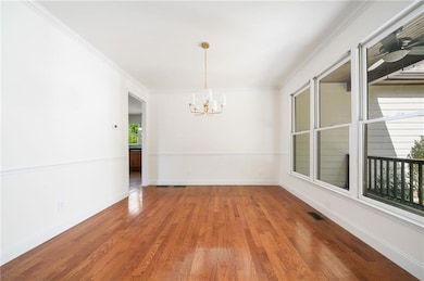 Unfurnished room featuring wood finished floors, v