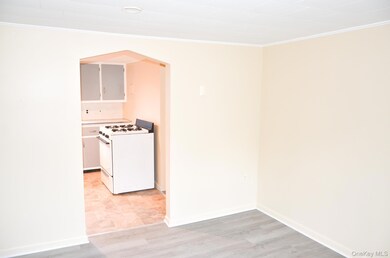 Kitchen featuring crown molding, white gas stove, light wood-type flooring, and arched walkways