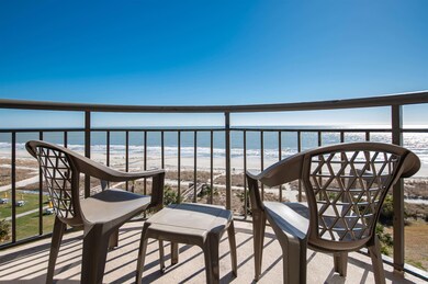 Balcony featuring view of water and beach