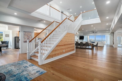 Stairs with hardwood / wood-style flooring, a towering ceiling, recessed lighting, baseboards, and ceiling fan