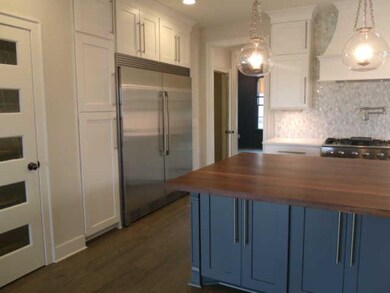 Beautiful kitchen boasts an oversized refrigerator