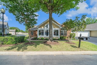View of front of home featuring a garage, a front yard, and brick siding