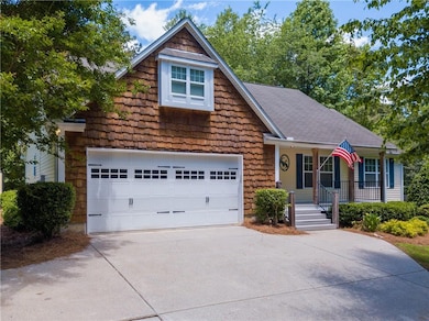 View of front facade featuring a porch, concrete driveway, and an attached garage