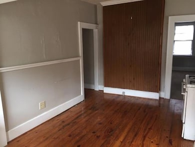 Unfurnished room with wood finished floors and baseboards
