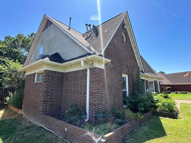 View of property exterior with brick siding and roof with shingles