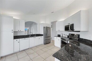 Kitchen featuring lofted ceiling, sink, white cabi